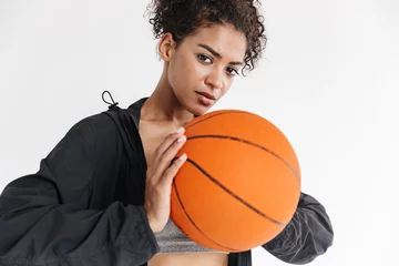 Gordijnen Beautful young amazing sports fitness african woman posing with basketball. © Drobot Dean