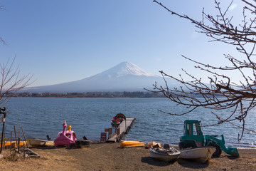 tree branches foreground, small dock on kawaguchiko lake and Fuji mountain