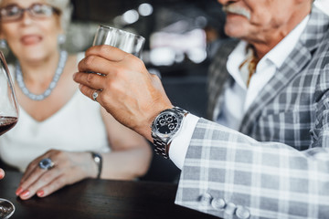 cropped view of smiling woman holding glass of wine with his husband at summer terrace