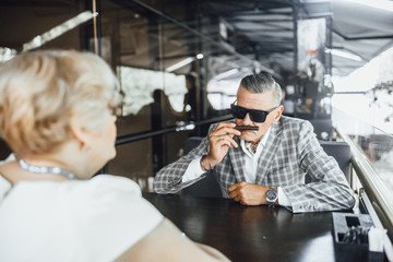 Attractive stylish senior man sniffs his favourite couban cigarette