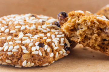 Closeup oatmeal cookies sprinkled with sesame. Background image. The concept of cooking, baking, homemade cookies. Top view, warm colors.