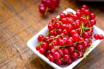 Fresh currant, organic currants in white bowl on table closeup