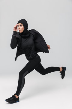 Fitness Muslim Woman Posing Running Jumping Isolated Over White Wall Background.