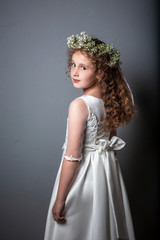 Caucasian girl wearing first holy communion dress. Girl preparing to take first communion. First Communion Day