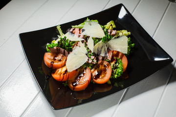 Veal steak salad with arugula, lettuce, tomato, olives and parmesan cheese