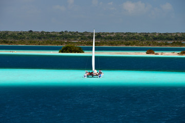 Catamaran on the azure water of the lagoon Bacalar the lake of seven colors.