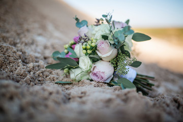 Obraz na płótnie Canvas wedding bouquet with roses on sand