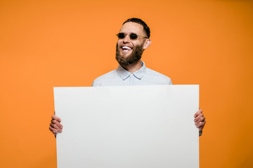 Hipster man holding a poster with blank space for your text.