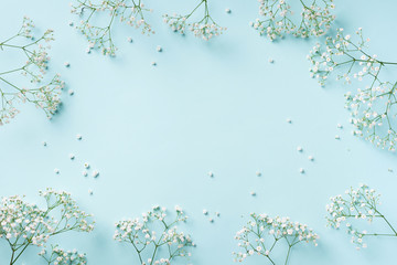 Small white gypsophila flowers on pastel blue background. Women's Day, Mother's Day, Valentine's Day, Wedding concept. Flat lay. Top view. Copy space
