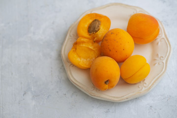 Apricots on a plate, concrete background with copy space