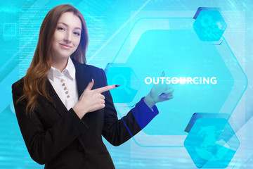 The concept of business, technology, the Internet and the network. A young entrepreneur working on a virtual screen of the future and sees the inscription: Outsourcing