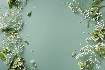 Zelfklevend Fotobehang Small white gypsophila flowers on pastel green background. Women's Day, Mother's Day, Valentine's Day, Wedding concept. Flat lay. Top view. Copy space © jchizhe