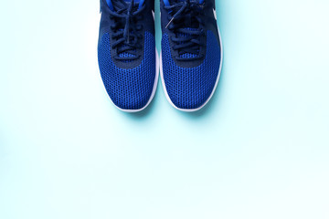 Pair of sport shoes on blue background. Top view, copy space. Fitness, running and sport concept. Healthy lifestyle