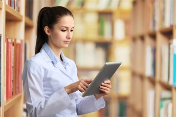 Nurse student with books and stethoscope in library