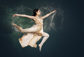 Dancer makes the jump. Beautiful background with flying particles of dust. The girl in the beige suit for modern dance.