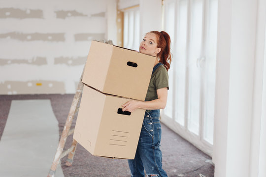 Young woman struggling with two cardboard boxes