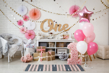 Birthday decorations with gifts, toys, garlands and figure for little baby party on a white bricks...