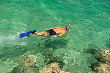 Man snorkeling in in turquoise water
