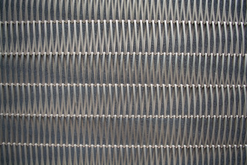Background or texture from a gray monophonic fence from metal the bound wire in several rows.