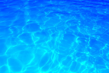 Blue color water in swimming pool rippled water detail background.