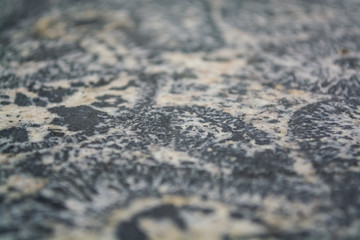 Background or texture from a gray stone with round spots and stains. Natural material. Glossy surface.