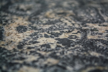 Background or texture from a gray stone with round spots and stains. Natural material. Glossy surface.