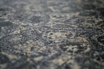 Background or texture from a gray stone with round spots and stains. Natural material. Glossy surface.