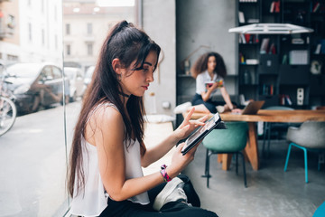 two young caucasian women working in modern loft