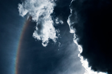 Dramatic storm dark sky with clouds and solar halo.