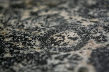 Background or texture from a gray stone with round spots and stains. Natural material. Glossy surface.