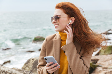 Lovely young redhead woman wearing autumn coat