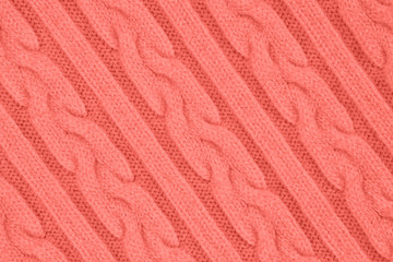 Fototapeta na wymiar Trendy coral colored Knitwear Fabric Texture with Pigtails and stripes. Repeating Machine Knitting Texture of Sweater. Knitted Background. Diagonal composition.
