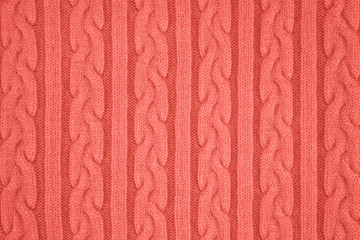 Trendy coral colored Knitwear Fabric Texture with Pigtails and stripes. Repeating Machine Knitting Texture of Sweater. Knitted Background. Color of the year 2019