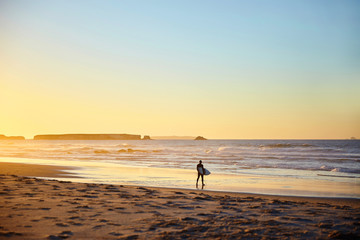 Fototapeta na wymiar surfer walks on the beach