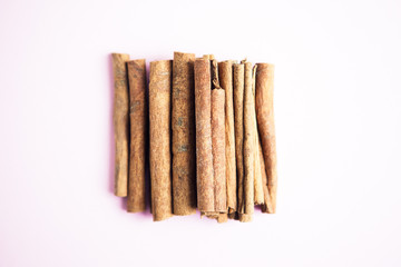Set of cinnamon sticks on pink background