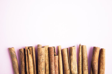 Set of cinnamon sticks on pink background