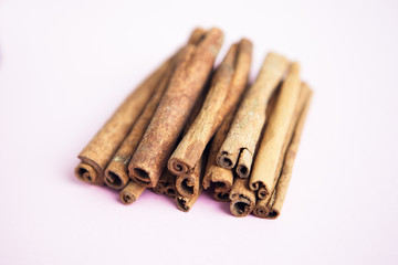 Set of cinnamon sticks on pink background