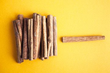 Set of cinnamon sticks on yellow background