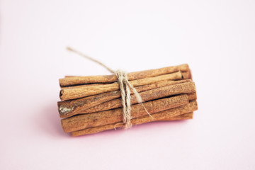 Set of cinnamon sticks on pink background