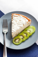 Homemade cottage cheese and semolina cake with kiwi fruit and cream on a plate