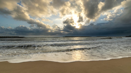 Sand, sea and clouds at sunrise