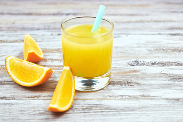 Fresh orange juice in a glass and orange slices on a shabby table light. horizontal view. detox. close-up. Copy space citrus refreshing drink.