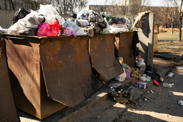 garbage bins are overfilled with packages with waste