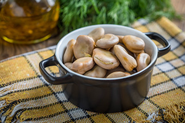 Broad beans served in black bowls.
