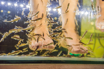 Young woman in a yellow dress at the fish spa