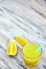 Fresh orange juice in a glass and orange slices on a light wooden table. vertical view. detox. view from above. citrus summer refreshing drink. copying text.
