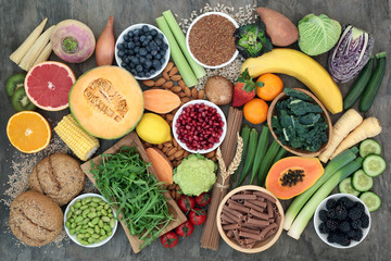 High fibre food for good health concept with fruit, vegetables, seeds, nuts, whole wheat pasta and...