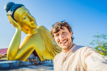 Happy man tourist on background ofLying Buddha statue