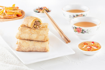 Traditional Chinese tortillas filled - bings in a plate on a white background, salads, Dam Sam snacks and cup of tea.