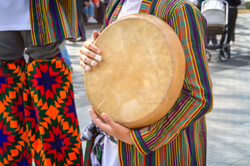 Street musician plays a traditional Asian musical instrument - doira. Close-up